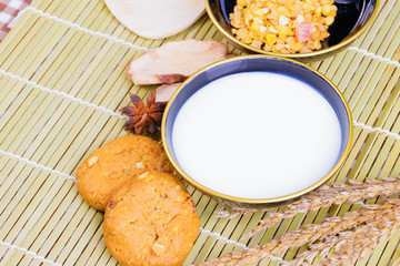 cereal cookies milk in bowl Cornflakes spices on wooden bamboo and copy space for text. top view
