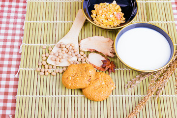 cereal cookies milk in bowl Cornflakes spices on wooden bamboo and copy space for text. top view