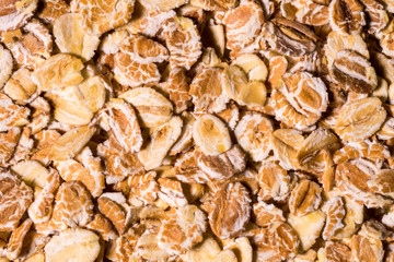 Flakes of porridge oat grits for oatmeal close up pattern background, elevated top view