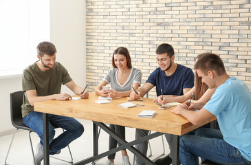 Fototapeta premium Group of young people sitting at table together, indoors. Unity concept