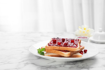 Toasts with jam and berries on plate, closeup