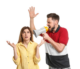 Young man with megaphone shouting at woman on white background
