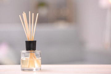 Handmade reed freshener on table against blurred background