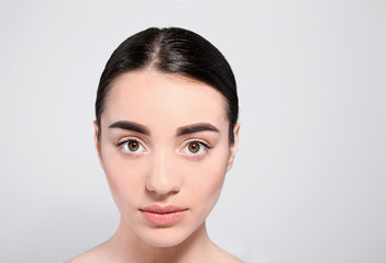 Fototapeta premium Beautiful woman with perfect eyebrows on light background