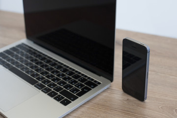 Laptop on wooden table notebook and phone