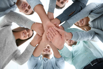 People putting hands together, view from below. Group therapy