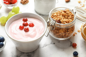 Bowl with yogurt, berries and granola on table