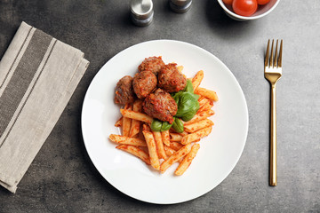 Delicious pasta with meatballs and tomato sauce on grey background, top view