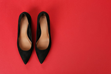 Pair of female shoes on color background, top view