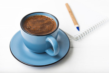 Coffee cup with notebook and pencil