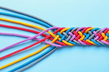 Braided ropes on color background, top view. Unity concept
