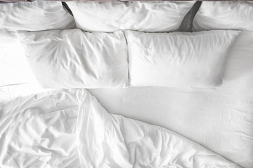 Comfortable bed with white linen at home