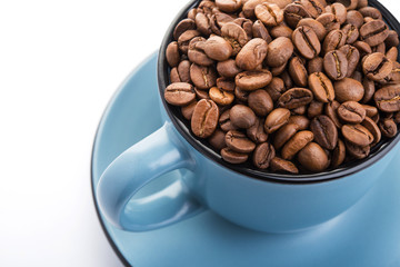 ceramic cup filled with roasted coffee beans