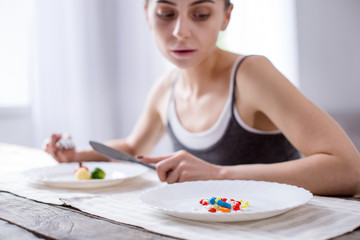 Obraz na płótnie Canvas Unhealthy medicine. Selective focus of a plate with a pile of pills on it