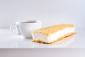 Cheesecake topped with Crumb and cup of coffee on white background-greatest breakfast. White icecream cake on wooden table. Shavuot, holiday, lifestyle, happy moments concept.