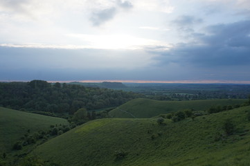 Fototapeta na wymiar Rolling fields rural landscape with a setting evening sun.