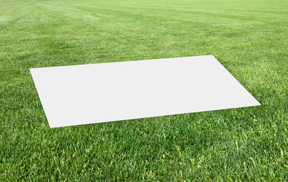 Blank sheet over a beautiful green mowed lawn - Concept image with copy space