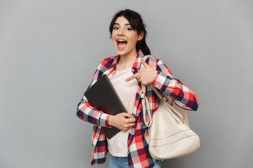 Amazing emotional young lady showing laptop computer.