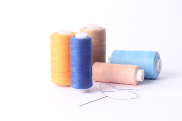 sewing thread of different colors isolated on white.