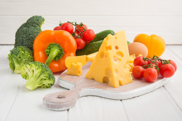 piece of cheese with fresh vegetables