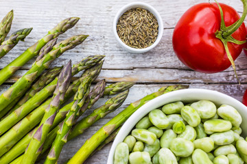 Fresh seasonal green vegetables asparagus and broad bean with tomatoes. 