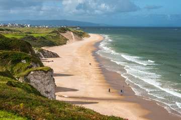 Panoramic view of people walking on Whiterocks Beach Portrush, Northern Ireland