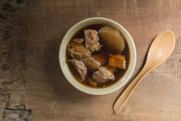top view of asian style tender boiled beef soup in a ceramic bowl on wooden table. healthy food concept.