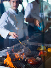 chef cooking steak with vegetables on a barbecue