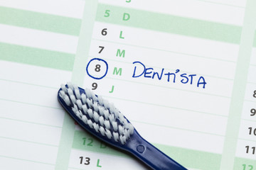 Cita dentista. Calendario y cepillo de dientes. Vista superior y de cerca