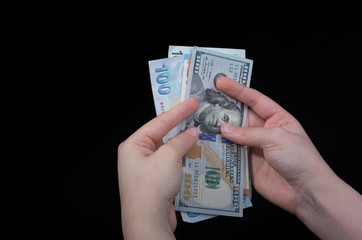 Hand holding American dollar  isolated on black background