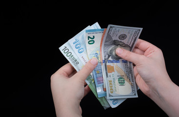Hand holding American dollar  isolated on black background