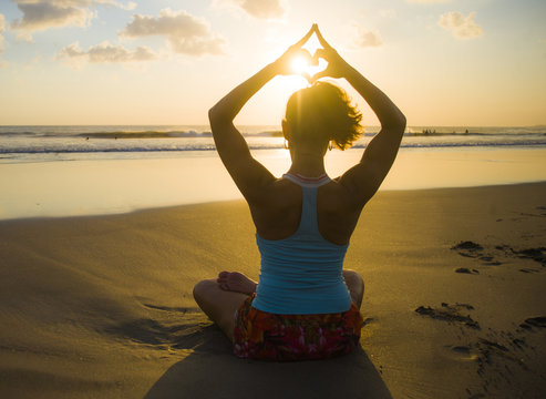 Silhouette Of Young Fit Sport Woman In Beach Sunset Yoga Practice In Meditation Doing Heart Shape With Hands And Fingers Against The Sun