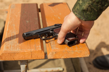 A man's hand takes a gun