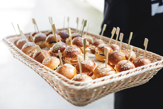 Waiter holding a tray with burgers 