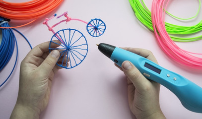 A girl is holding 3d pen and retro bike made of plastic