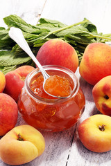Peach vanilla jam with fresh peaches on table.