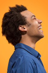 Obraz premium The happy business man standing and smiling against orange background.