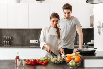 Portrait of a cheerful young couple cooking
