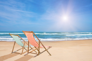 Fototapeta na wymiar Chairs on the sandy beach near the sea. Summer holiday and vacation
