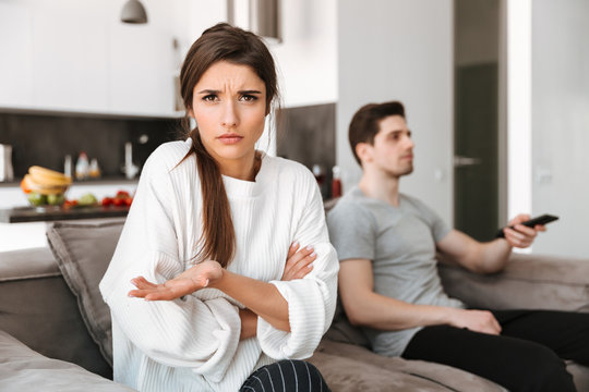 Portrait of a frustrated young woman sitting with her boyfriend