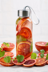 Fototapeta na wymiar Detox infused water flavored with bloody orange and mint. Healthy refreshing beverage.