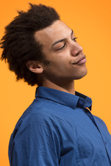 Obraz premium Beautiful male half-length portrait isolated on orange studio backgroud. The young emotional surprised man