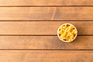 Uncooked fusilli pasta . Wooden background . Italian Food . Empty space for text