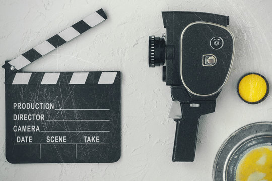 A movie camera, a clapperboard, a film box and a yellow filter