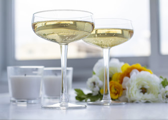 Two glasses of champagne with flowers and candles