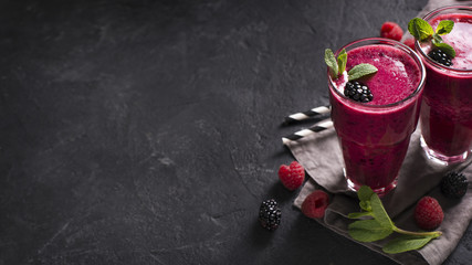 Blackberry and raspberry smoothies in glass with mint leaf and raw beeries
