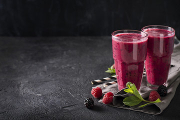 Blackberry and raspberry smoothies in glass with mint leaf and raw beeries
