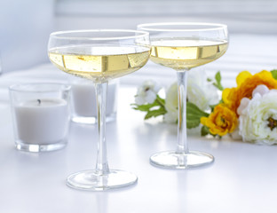 Two glasses of champagne with flowers and candles