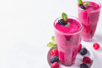 Blackberry and raspberry smoothies in glass with mint leaf and raw beeries
