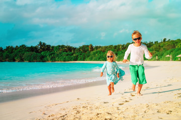 little boy and girl run play at beach
